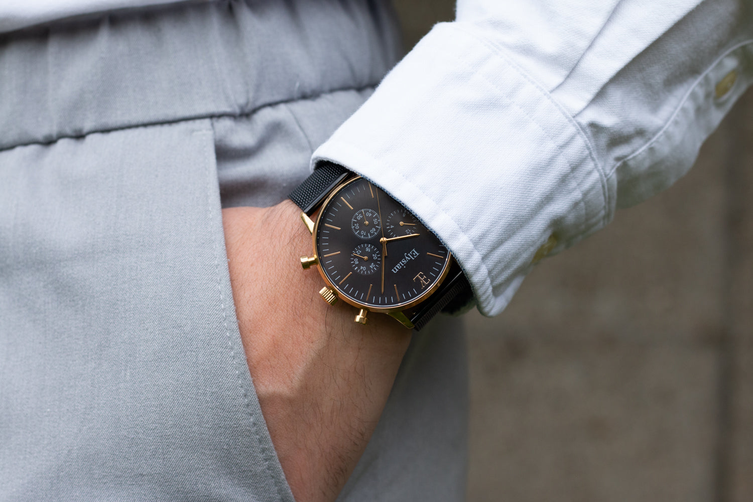 elysian-gouden-heren-horloge-zwart-plaat-zwart-mesh-horlogeband-ELYWM00130-hand